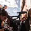 Film students surround a camera and film a scene outside of a restaurant.